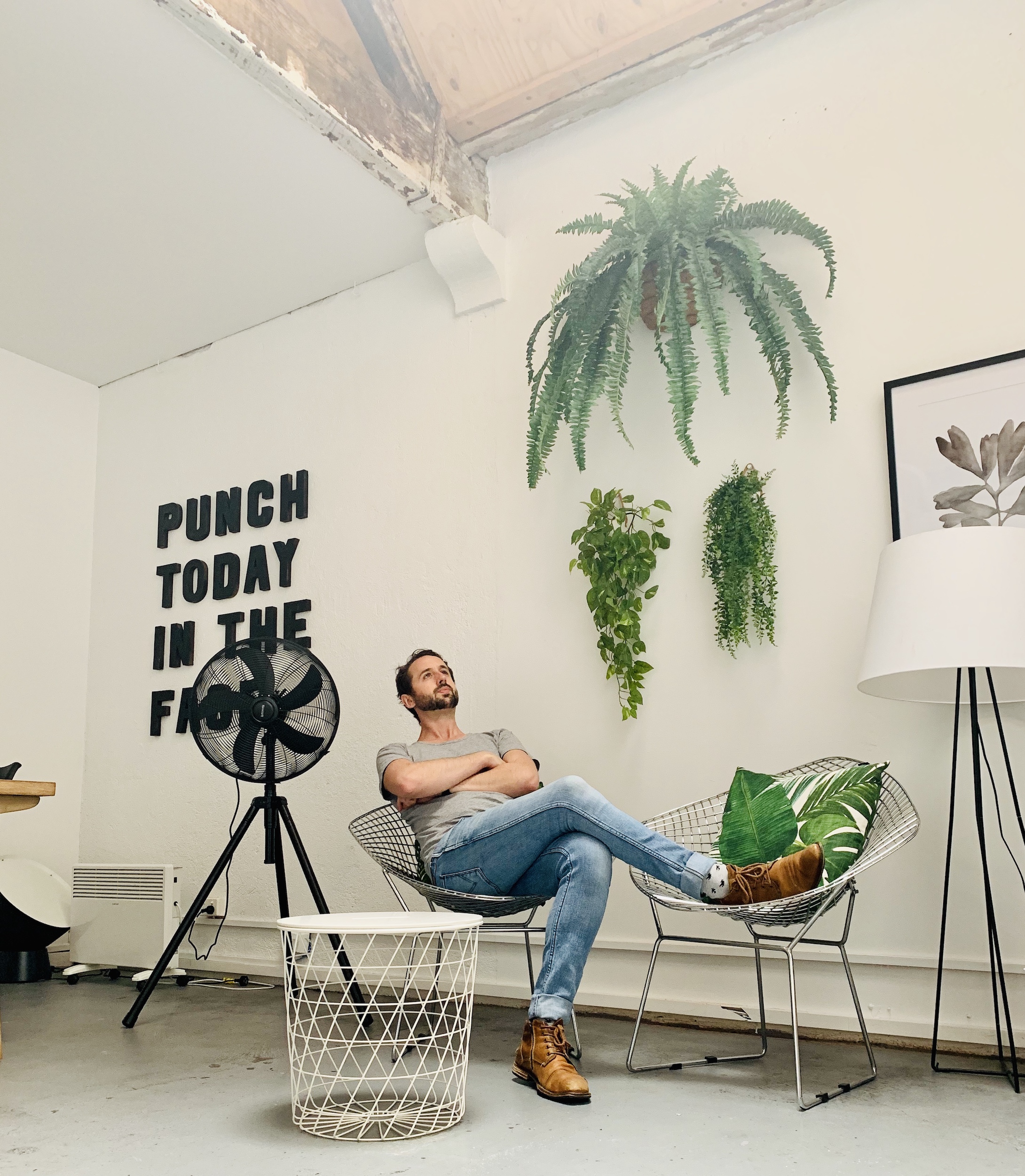 Sam Macaulay relaxing in a chair in a trendy design studio space.